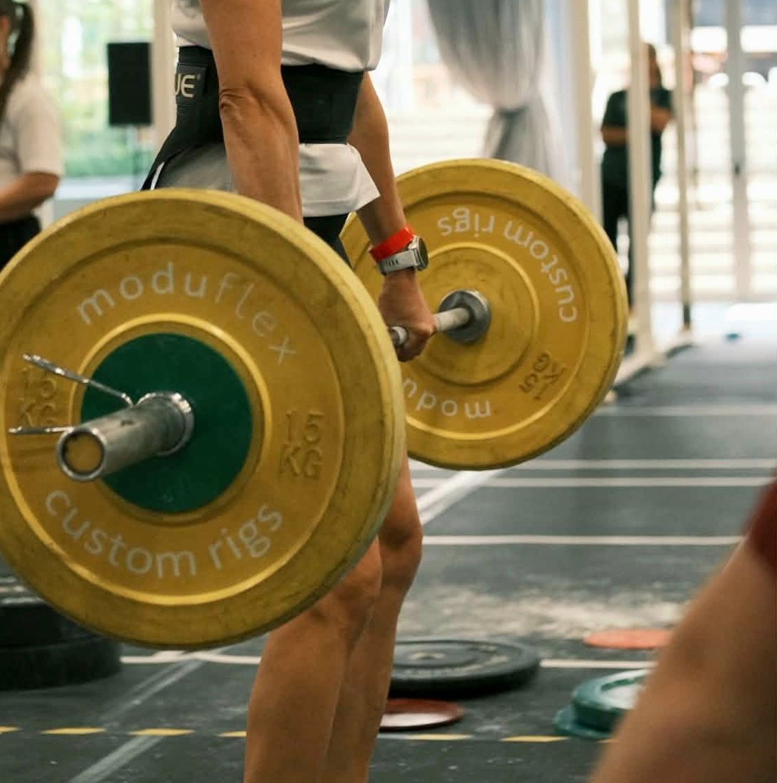 Štanga su geltonais svarmenimis kilnojama nuo grindų