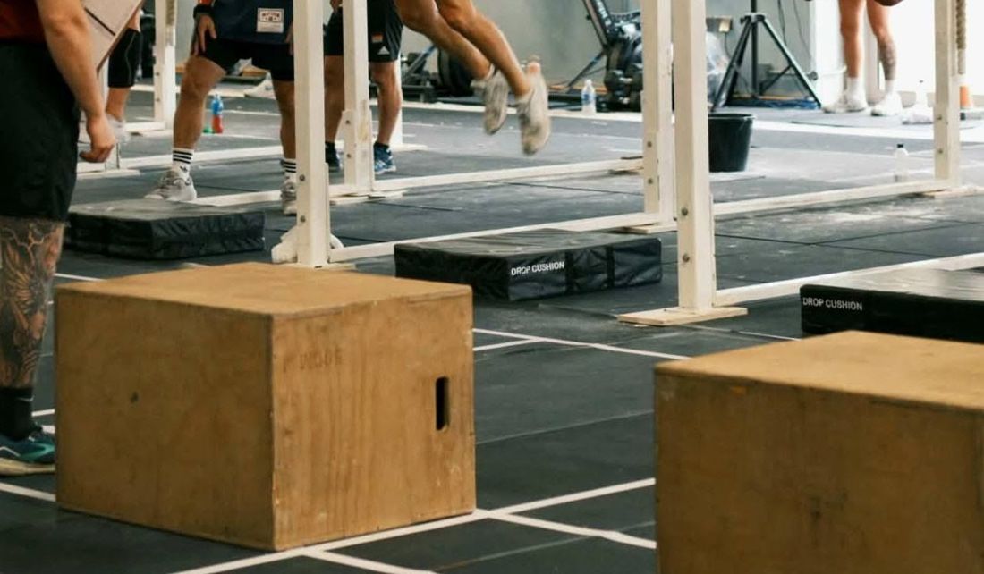 Funkcinio sporto varžybos: medinės dėžės ir atletų kojos prie skersinių